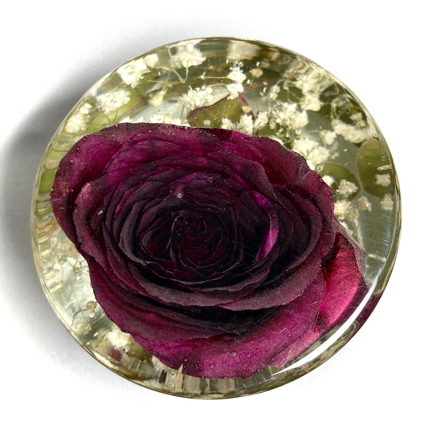 Cylinder containing a red rose, gypsophila and foliage