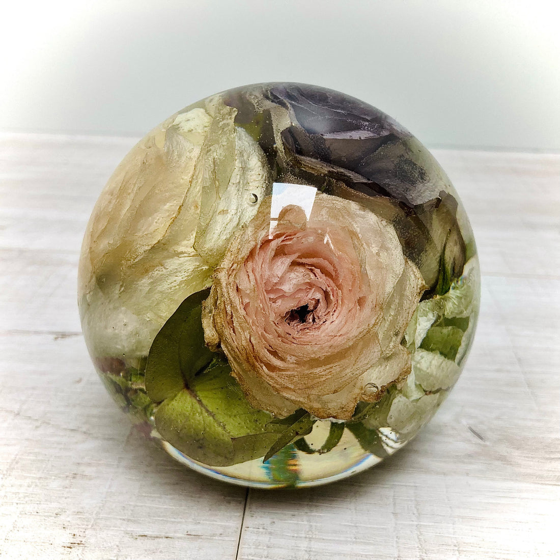 A beautiful 14cm spherical glass dome displaying preserved wedding flowers. The delicate petals and vibrant colors are encased in a clear and smooth glass ball, making it a timeless and unique keepsake to remember your special day