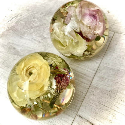 A decorative sphere paperweight made of resin, showcasing beautifully preserved wedding flowers, adding a unique and memorable touch to any space.