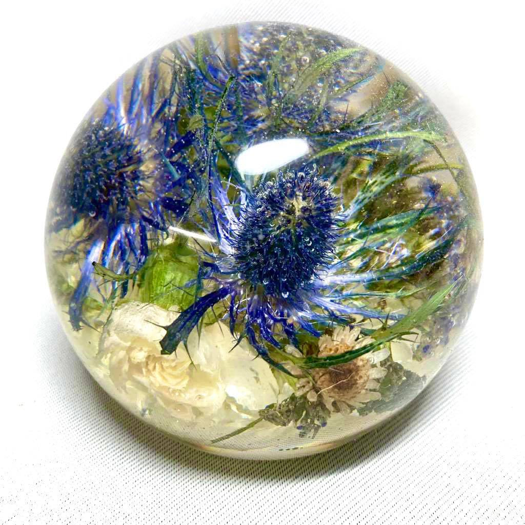 A decorative sphere paperweight made of resin, showcasing beautifully preserved wedding flowers, adding a unique and memorable touch to any space.