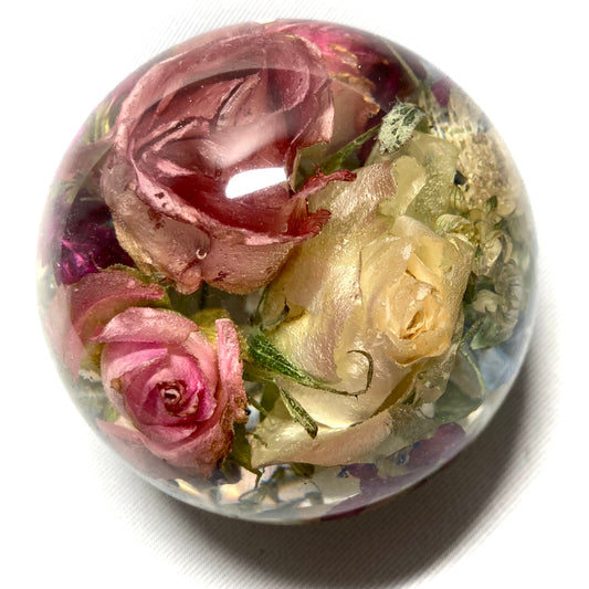 8cm flat bottom sphere containing a mixture of pink and white roses, blossoms and foliage