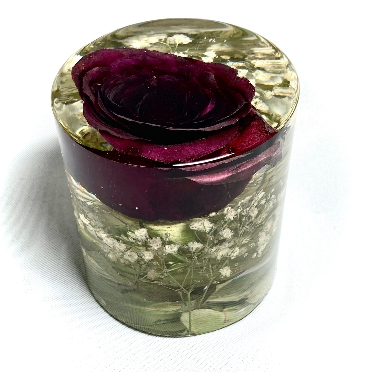 Cylinder containing a red rose, gypsophila and foliage